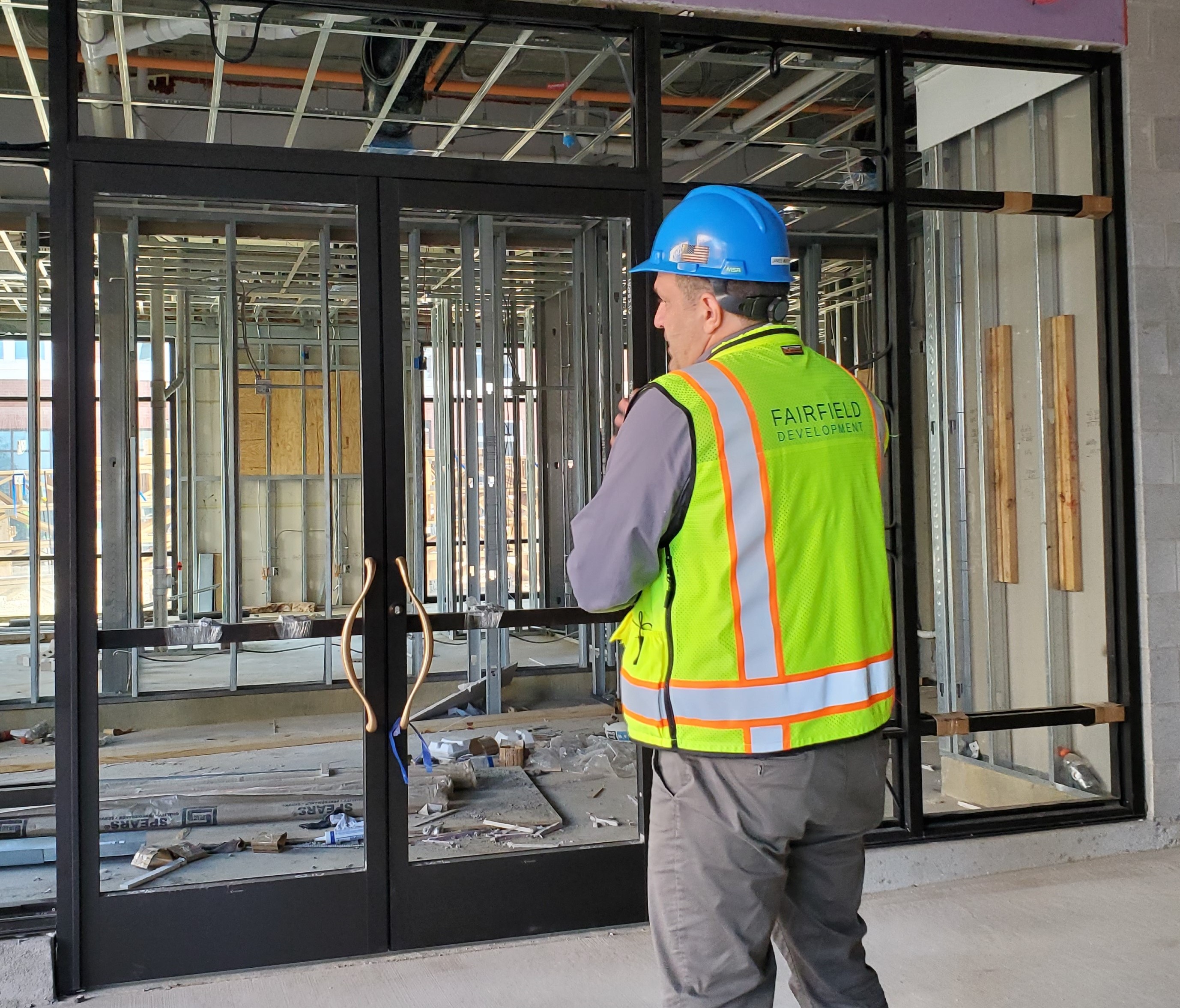 A Fairfield construction associate stands in front of a building under development.