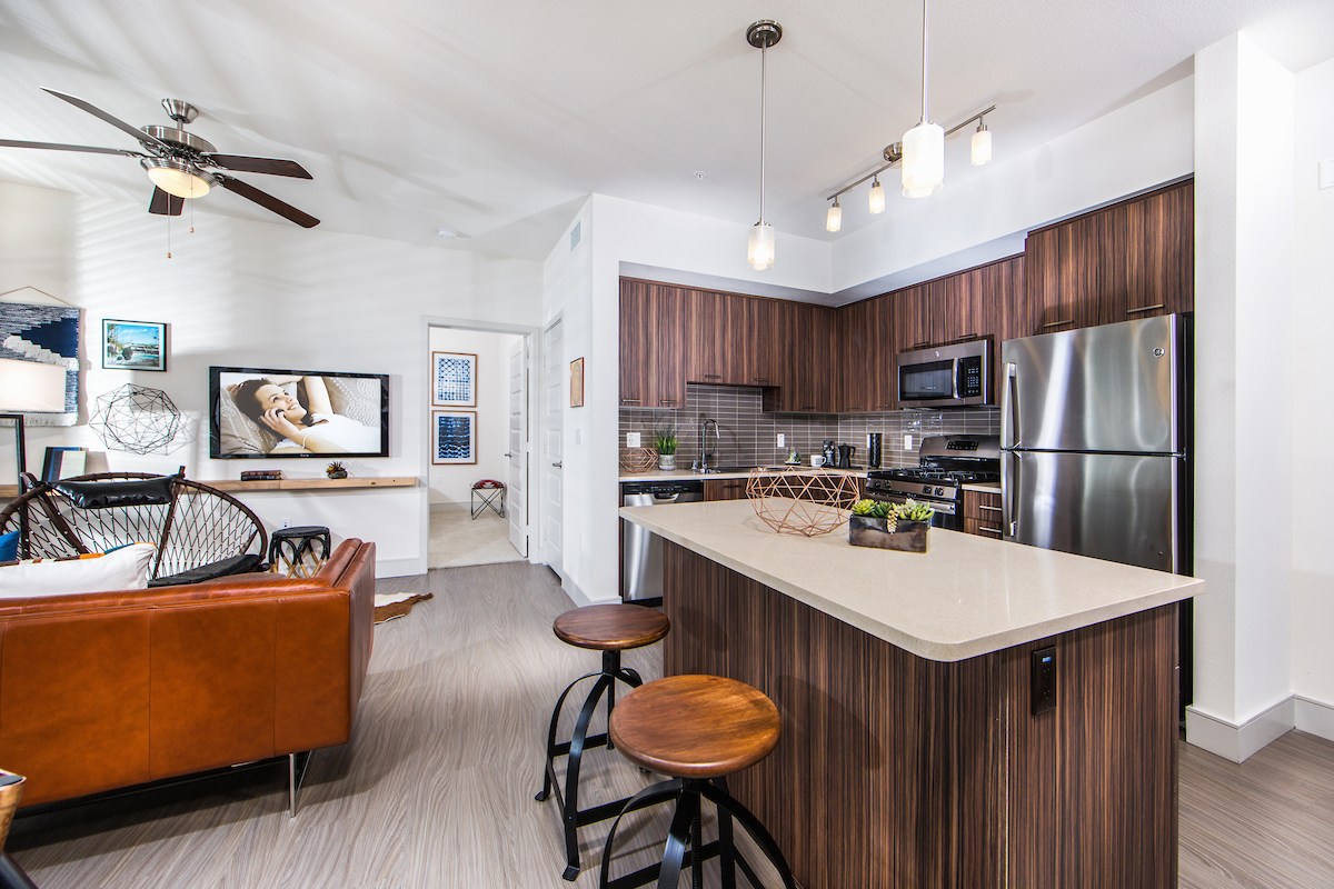 Open-concept kitchen with island leads into the living room at Avaire Apartments