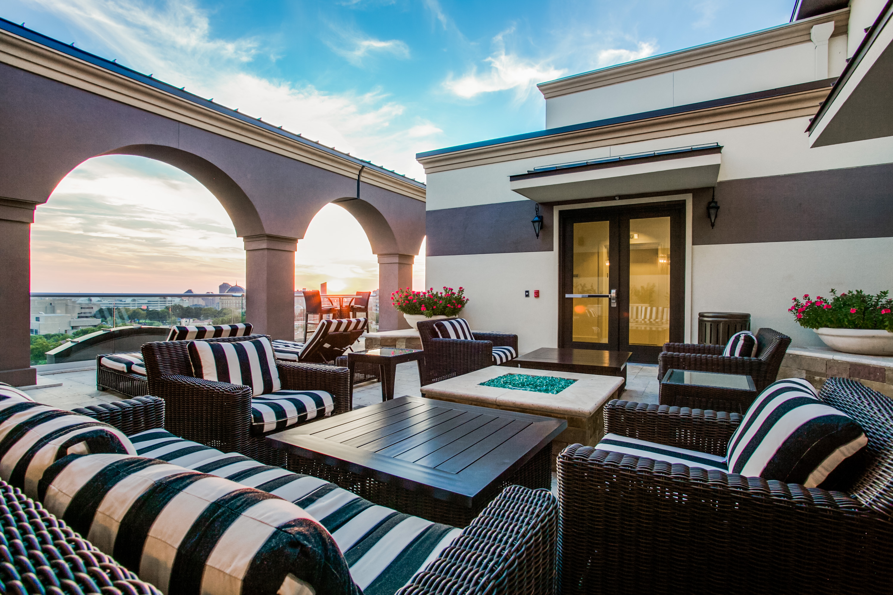 Exterior courtyard of Cantabria Apartments with plush striped patio seating at golden hour