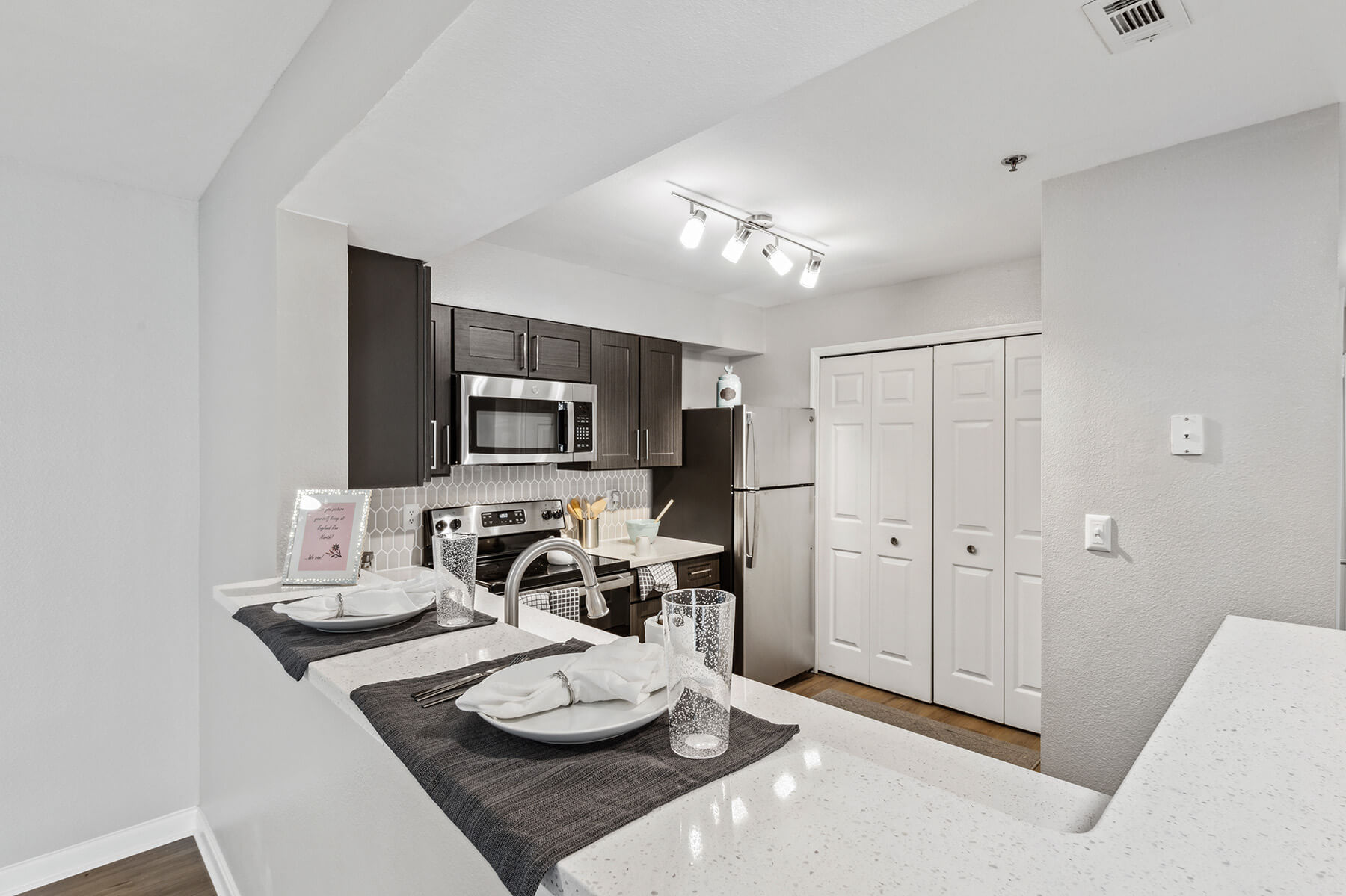 A white kitchen with dark cabinets at the England Run North Apartments in Fredericksburg, Virginia.