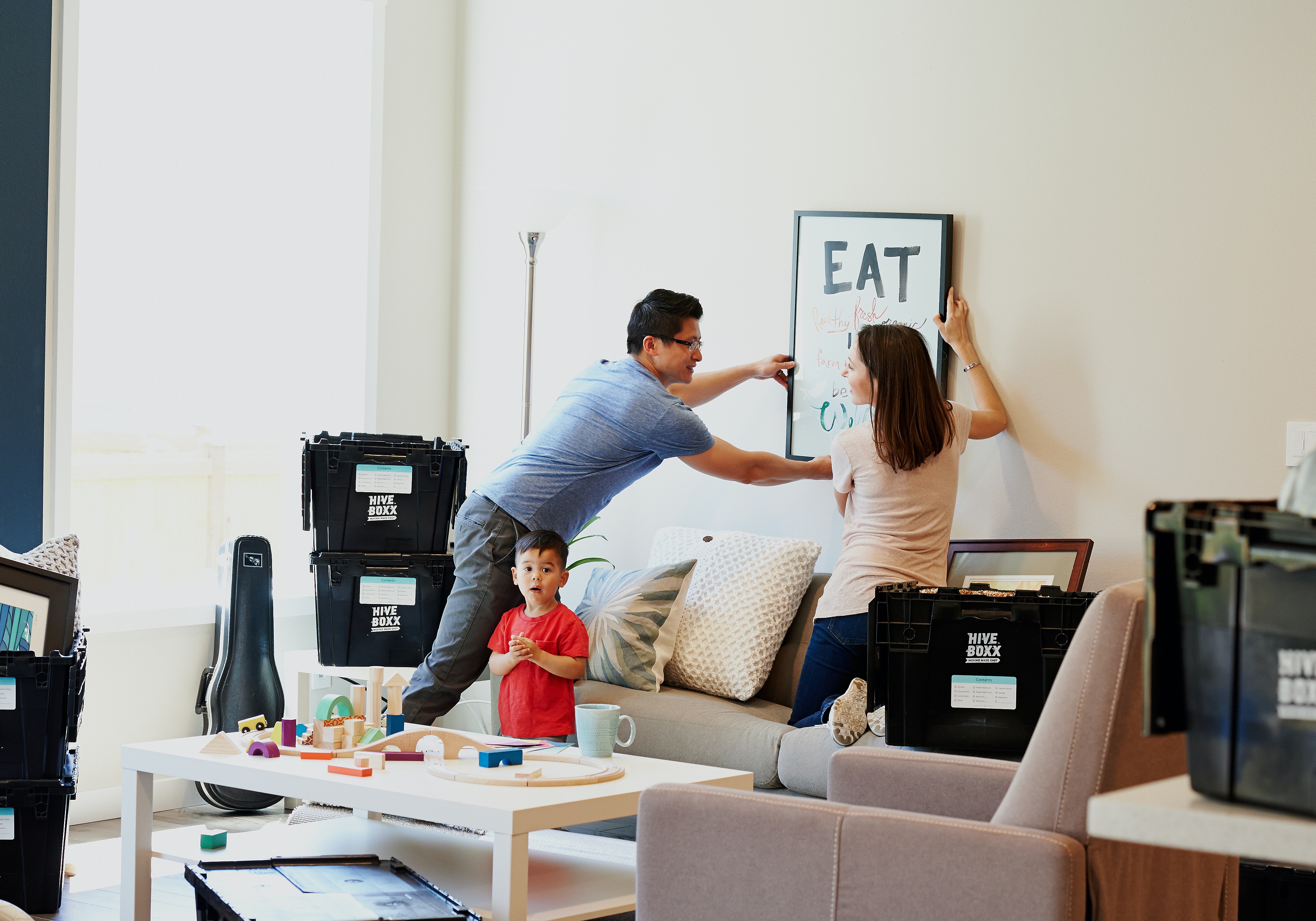 A family decorates their new living room after moving in.