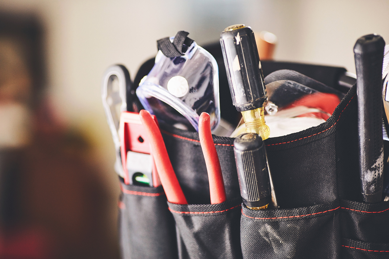 A close-up of a tool bag filled with various tools.