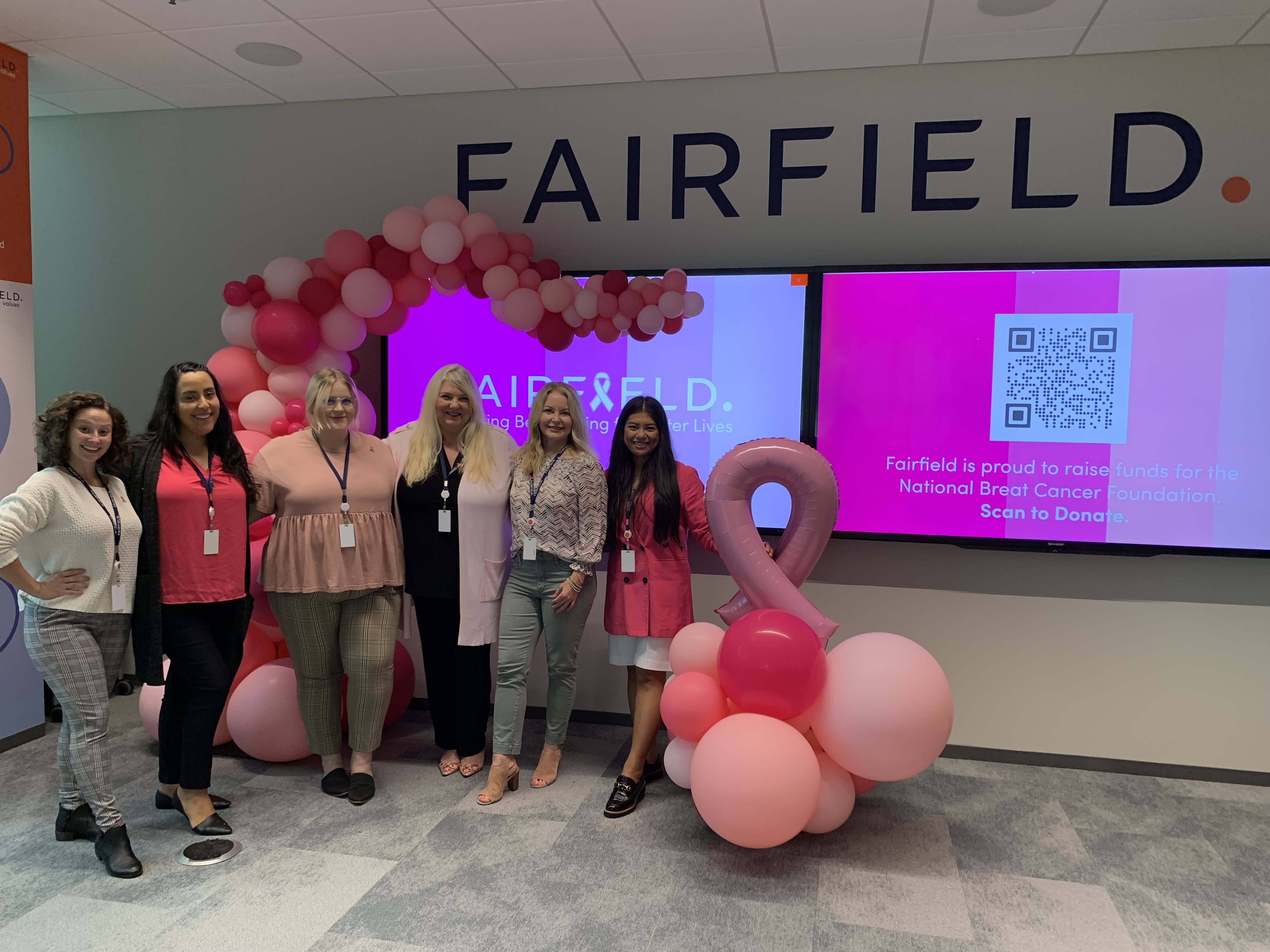 Associates wearing pink gather to celebrate BCAM at Fairfield HQ