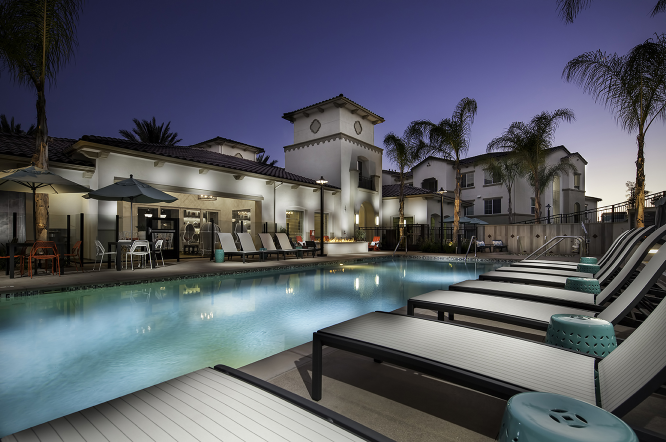 Exterior of Seta apartments at night as seen across the pool from a chaise lounge