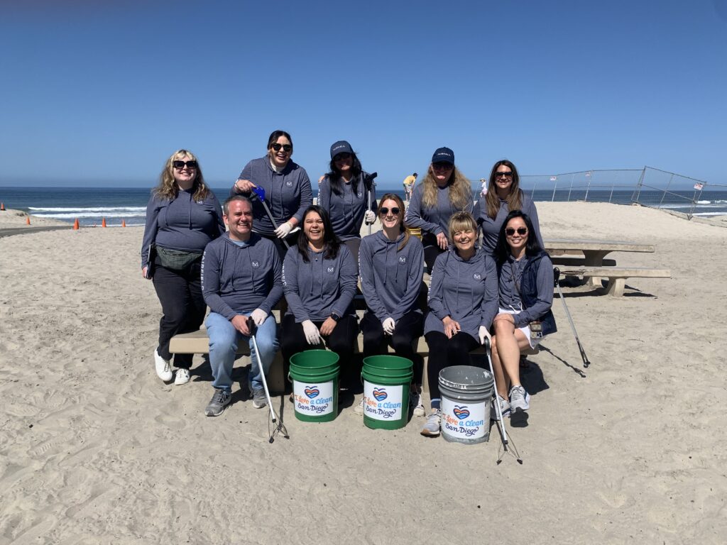 Fairfield associates posing at Moonlight Beach for Earth Day