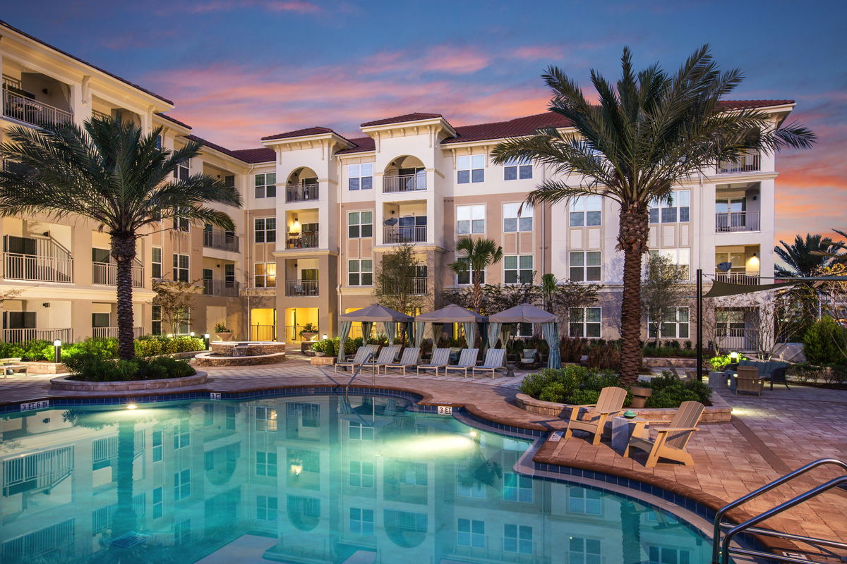 Exterior of The Views at Harbortown from the pool against a golden-hour sky